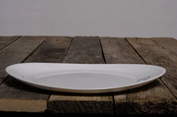 Vista superior de plato blanco en blanco y mantel blanco sobre un fondo de madera con espacio para copiar — Foto de Stock
