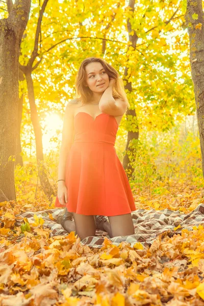 A woman is posing in front of a camera in an autumn park. autumn photo shoot. Autumn in the park. — Stock Photo, Image