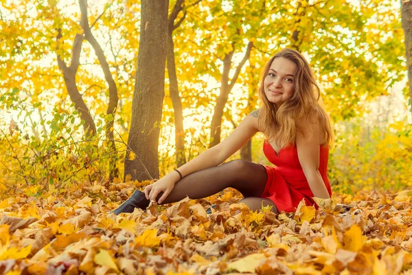 A woman is posing in front of a camera in an autumn park. autumn photo shoot. Autumn in the park. — Stock Photo, Image