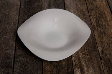 Kopya alanı ile ahşap arka plan üzerinde boş beyaz çanak ve beyaz masa örtüsü üst görünümü