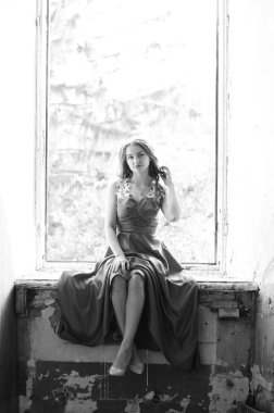 Genç, kısa saçlı, siyah elbiseli, merdivenlerden çıkan sarışın, siyah beyaz bir kadın. Film yıldızı olan zarif, romantik bir kadının yan görünüşü. Duvarlarla iç kısımlara bak.