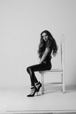 Çekici esmer güzellik sandalyede oturuyor.