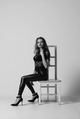 Çekici esmer güzellik sandalyede oturuyor.