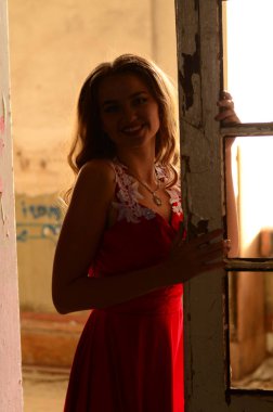 Duvarın yanında güzel, modern elbiseli bir kız. Gençlik Alanı