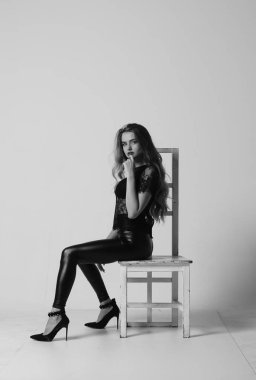 Çekici esmer güzellik sandalyede oturuyor.