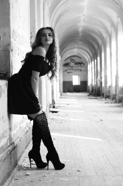 Genç, kısa saçlı, siyah elbiseli, merdivenlerden çıkan sarışın, siyah beyaz bir kadın. Film yıldızı olan zarif, romantik bir kadının yan görünüşü. Duvarlarla iç kısımlara bak.