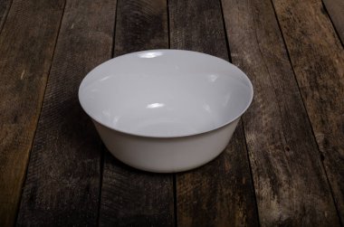 Kopya alanı ile ahşap arka plan üzerinde boş beyaz çanak ve beyaz masa örtüsü üst görünümü