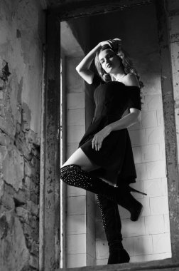 Genç, güzel, kısa saçlı, siyah elbiseli sarışın kadın.