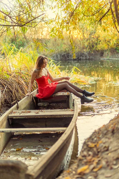 Uma mulher está posando na frente de uma câmera em um parque de outono. sessão de fotos de outono. Outono no parque . — Fotografia de Stock