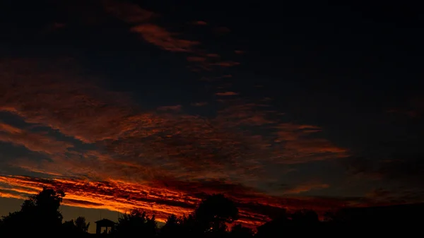 Himmelblått och orange solljus genom molnen på himlen — Stockfoto