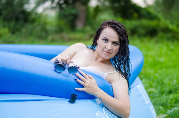 Dívka v prádle a bílou košili spočívá v bazénu s mlékem — Stock fotografie
