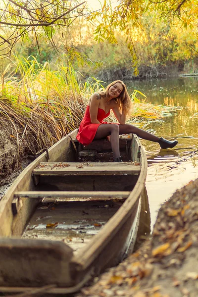 En kvinna poserar framför en kamera i en park på hösten. höst foto shoot. Hösten i parken. — Stockfoto