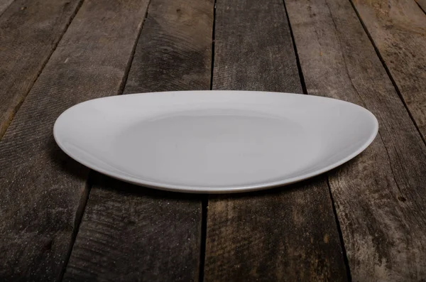 Top view of blank white dish and white tablecloth on a wood background with copy space — Stock Photo, Image