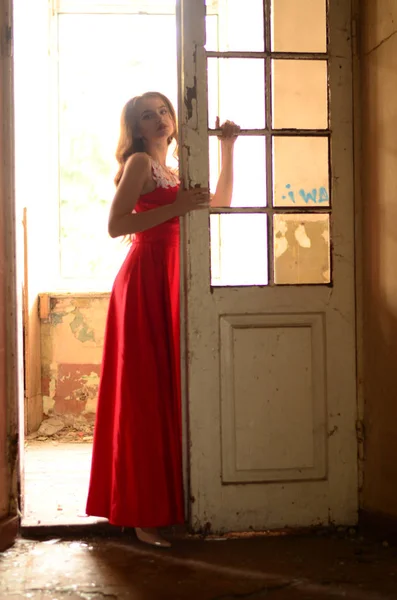 在砖墙附近穿着红色衣服的漂亮的现代女孩。 青春气息 — 图库照片
