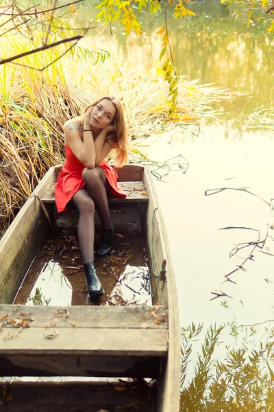 Uma mulher está posando na frente de uma câmera em um parque de outono. sessão de fotos de outono. Outono no parque . — Fotografia de Stock