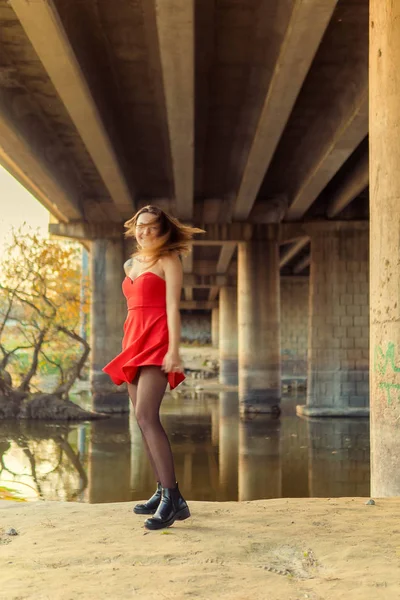 En kvinna poserar framför en kamera i en park på hösten. höst foto shoot. Hösten i parken. — Stockfoto