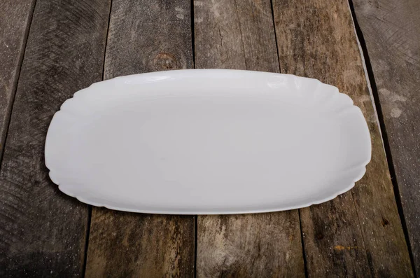 Κορυφαία θέα από κενό λευκό πιάτο και λευκό τραπεζομάντηλο σε φόντο ξύλου με χώρο αντιγραφής — Φωτογραφία Αρχείου