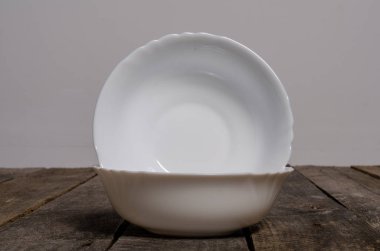 Kopya alanı ile ahşap arka plan üzerinde boş beyaz çanak ve beyaz masa örtüsü üst görünümü