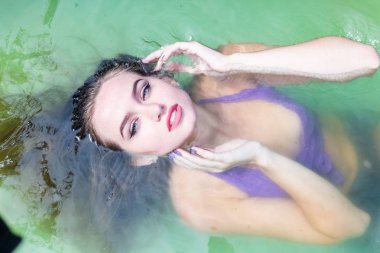 Islak modeli duş alır ve giyim, ıslak giyim, kadın, ıslak bak sauna ve yüzme havuzunda yüzüyor