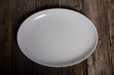 Kopya alanı ile ahşap arka plan üzerinde boş beyaz çanak ve beyaz masa örtüsü üst görünümü
