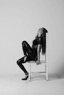 Çekici esmer güzellik sandalyede oturuyor.