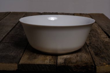 Kopya alanı ile ahşap arka plan üzerinde boş beyaz çanak ve beyaz masa örtüsü üst görünümü