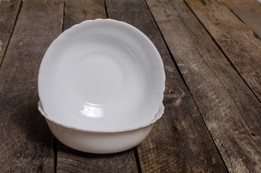 Kopya alanı ile ahşap arka plan üzerinde boş beyaz çanak ve beyaz masa örtüsü üst görünümü