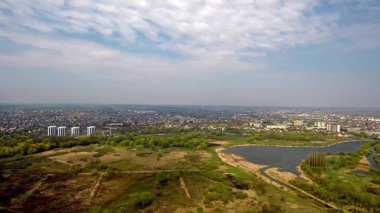 Gün batımında kıyıda bir köy ve sanayi bölgesi olan nehir dallarının hava görüntüleri.