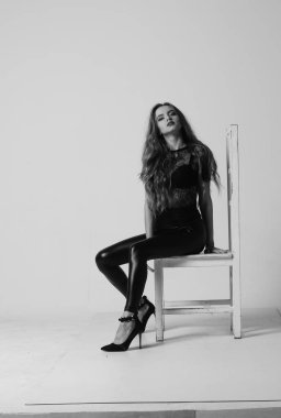 Çekici esmer güzellik sandalyede oturuyor.