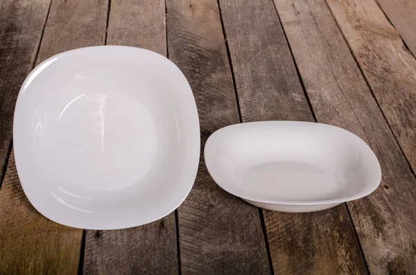 Top view of blank white dish and white tablecloth on a wood background with copy space — Stock Photo, Image