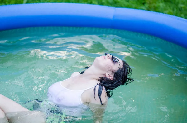Mädchen in Dessous und weißem Hemd liegt in einem Pool mit Milch — Stockfoto