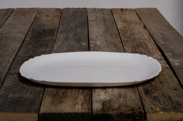 Vista dall'alto del piatto bianco bianco e tovaglia bianca su uno sfondo di legno con spazio per la copia — Foto Stock