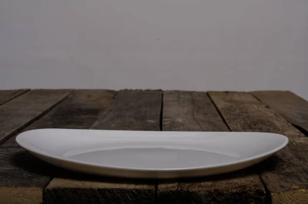 在木材背景上提供空白白色盘子和白色桌布的顶视图，并带有复制空间 — 图库照片