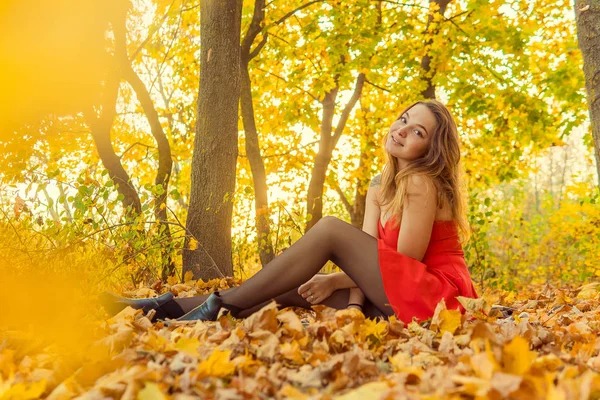 A woman is posing in front of a camera in an autumn park. autumn photo shoot. Autumn in the park. — Stock Photo, Image