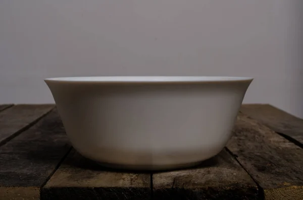 Vista superior do prato branco em branco e toalha de mesa branca em um fundo de madeira com espaço de cópia — Fotografia de Stock