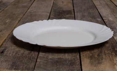 Kopya alanı ile ahşap arka plan üzerinde boş beyaz çanak ve beyaz masa örtüsü üst görünümü