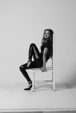 Çekici esmer güzellik sandalyede oturuyor.