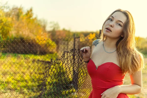 Uma mulher está posando na frente de uma câmera em um parque de outono. sessão de fotos de outono. Outono no parque . — Fotografia de Stock