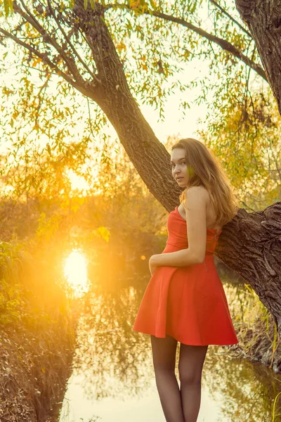 En kvinna poserar framför en kamera i en park på hösten. höst foto shoot. Hösten i parken. — Stockfoto