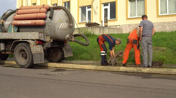 Trabajador de alcantarillado en tubería de limpieza de la calle, buzo de reparación de alcantarillado Lutsk Ucrania 08 / 01 / 2018 — Foto de Stock