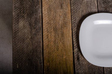 Kopya alanı ile ahşap arka plan üzerinde boş beyaz çanak ve beyaz masa örtüsü üst görünümü