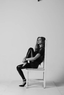 Çekici esmer güzellik sandalyede oturuyor.