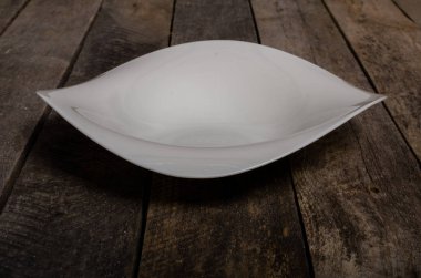 Kopya alanı ile ahşap arka plan üzerinde boş beyaz çanak ve beyaz masa örtüsü üst görünümü