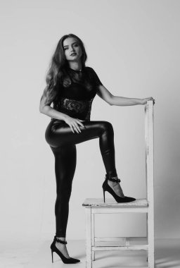 Çekici esmer güzellik sandalyede oturuyor.