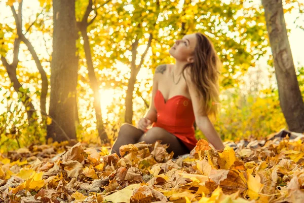 Una mujer posa delante de una cámara en un parque de otoño. sesión de fotos de otoño. Otoño en el parque . — Foto de Stock