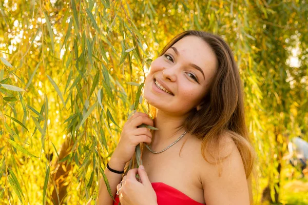 Eine Frau posiert in einem herbstlichen Park vor einer Kamera. Herbst-Fotoshooting. Herbst im Park. — Stockfoto