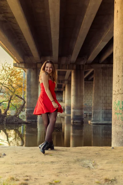 Uma mulher está posando na frente de uma câmera em um parque de outono. sessão de fotos de outono. Outono no parque . — Fotografia de Stock