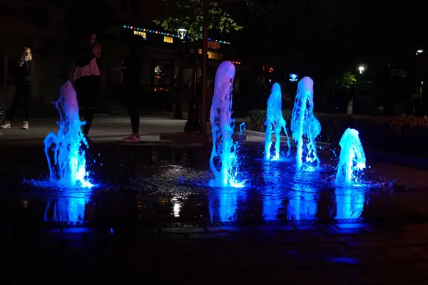 Fuente con coloridas iluminaciones por la noche —  Fotos de Stock