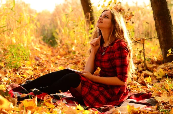 Outdoor fashion photo of young beautiful lady surrounded autumn leaves — Stock Photo, Image