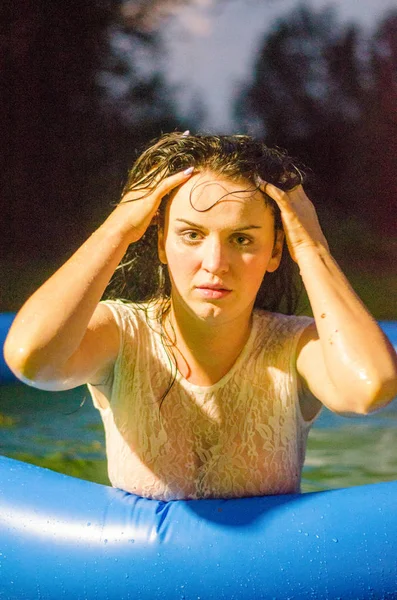 Mädchen in Dessous und weißem Hemd liegt in einem Pool mit Milch — Stockfoto